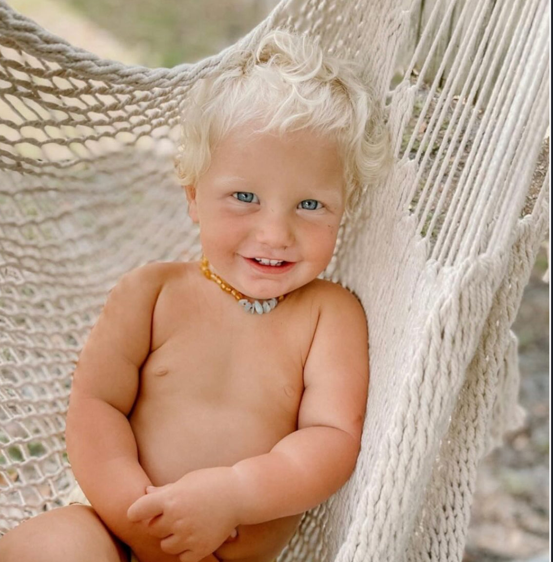 Kids beaded necklace with warm amber-gold beads and small blue stone accent