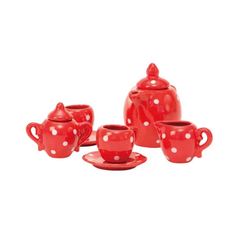 Red ceramic tea set with white polka dots, including teapot, cups, and saucers
