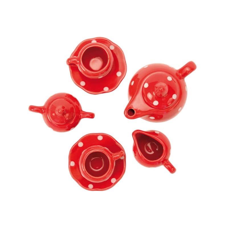 Red polka dot ceramic tea set viewed from above, showing cups, teapot, and saucers