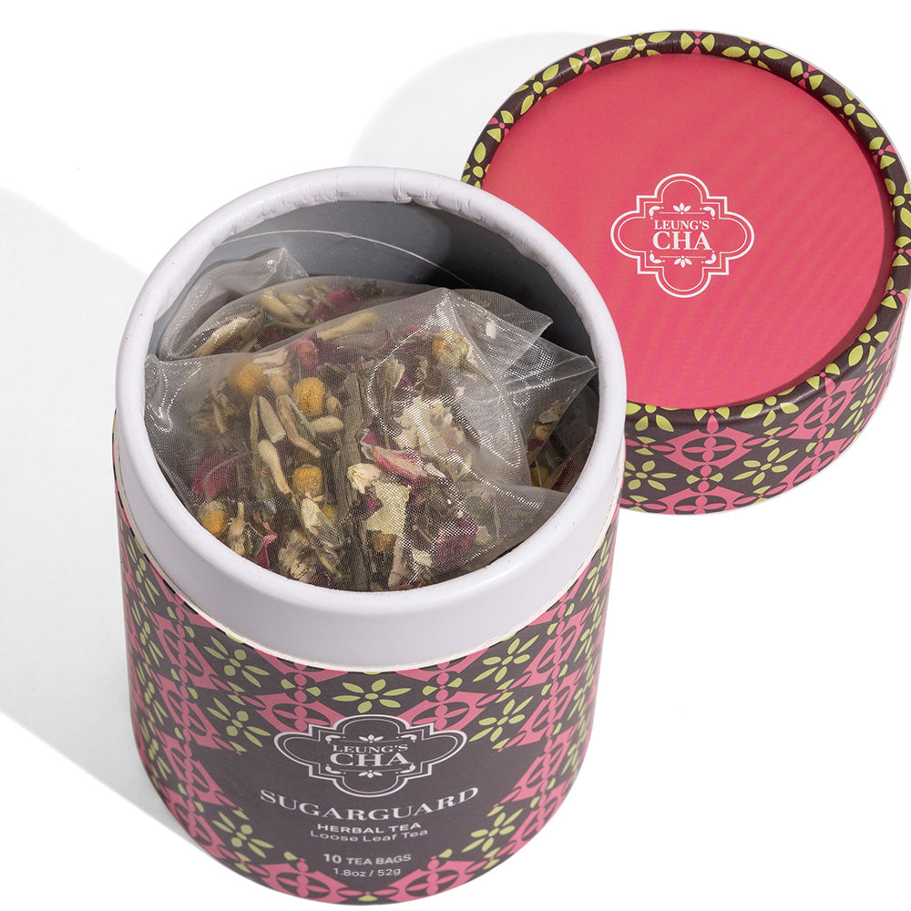 Herbal tea tin with open top and visible tea leaves inside, pink patterned lid