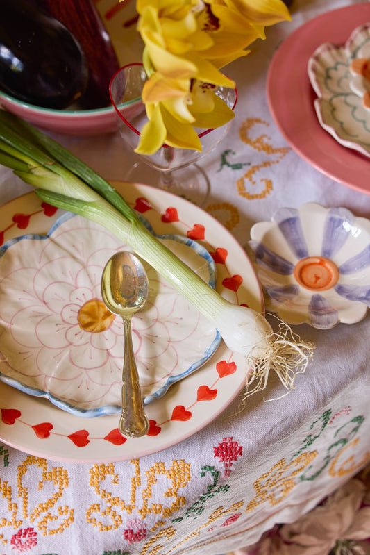Flower-shaped ceramic side plate with blue edge, pink floral center and rim