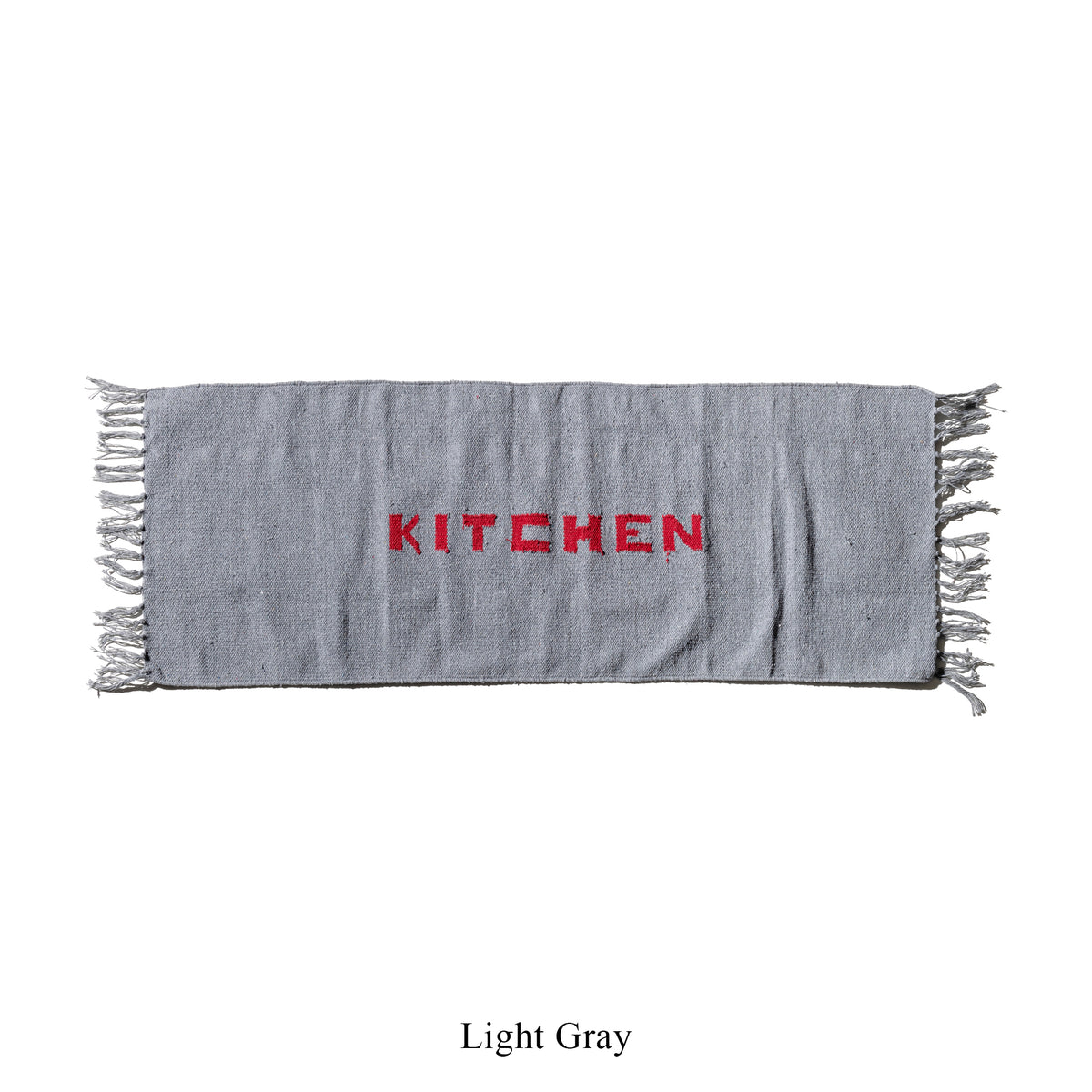 Light gray kitchen mat with fringe edges and red 'KITCHEN' lettering