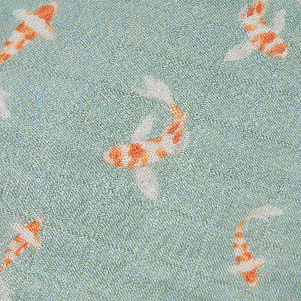 Close-up of teal fabric with scattered orange koi fish print