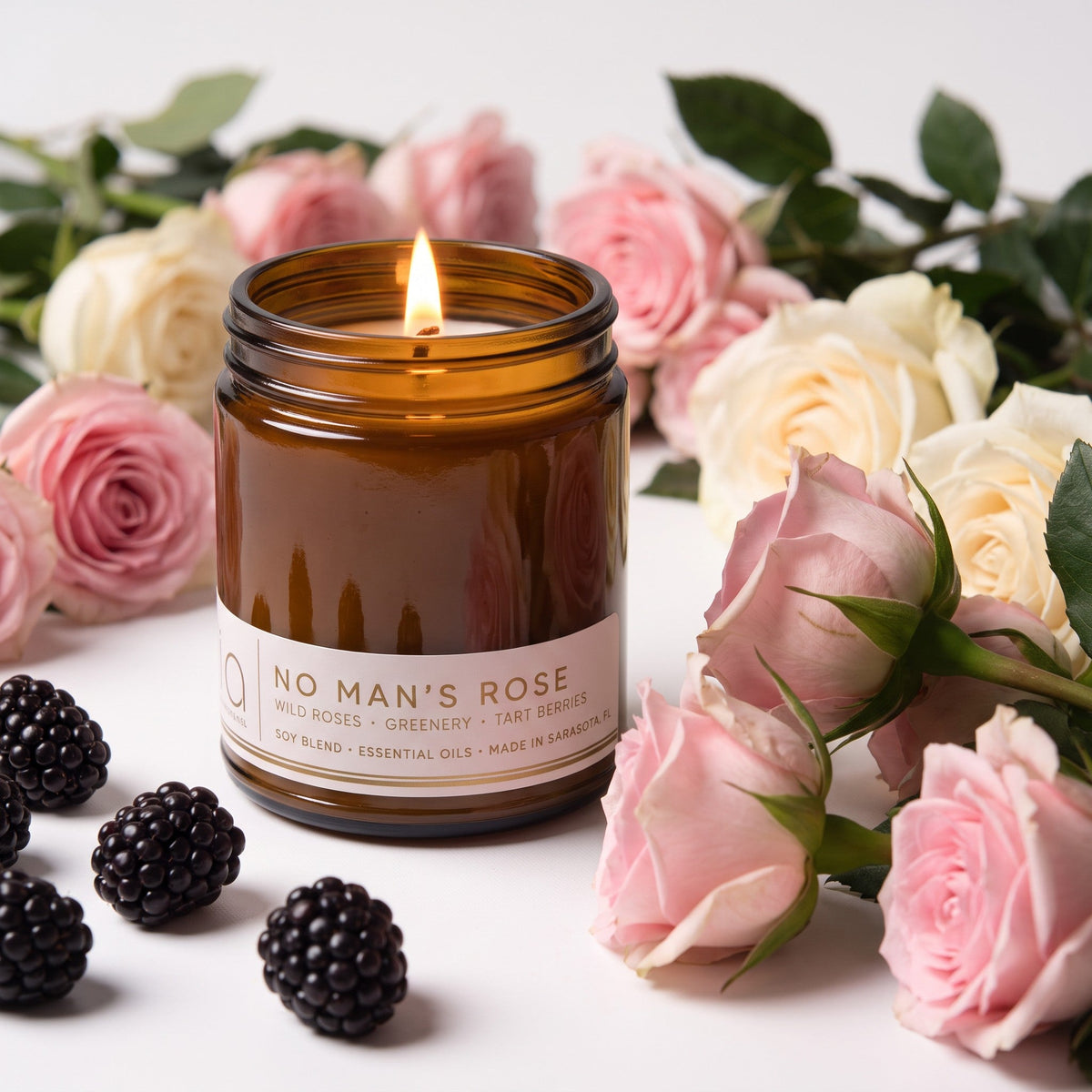 Amber glass soy candle jar with lit wick and white front label.
