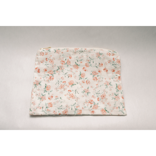 Floral zipper pouch with pastel rose and greenery print on light fabric, ruffled bottom edge
