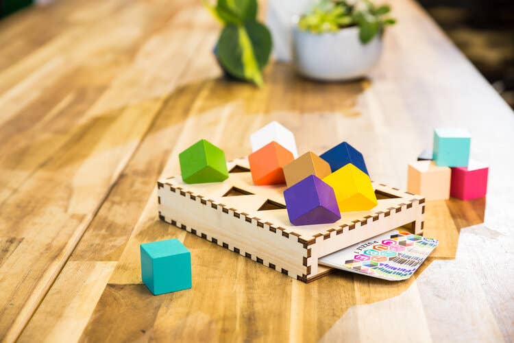 Multicolor cubes on wooden tray with instruction cards on tabletop