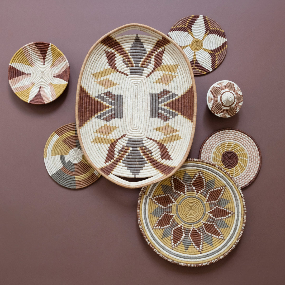 Assorted woven flower-burst coasters in cream, brown, gray, and blue tones