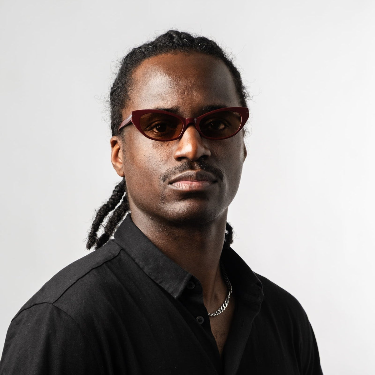 Model wearing burgundy cat-eye sunglasses with amber tinted lenses, front view