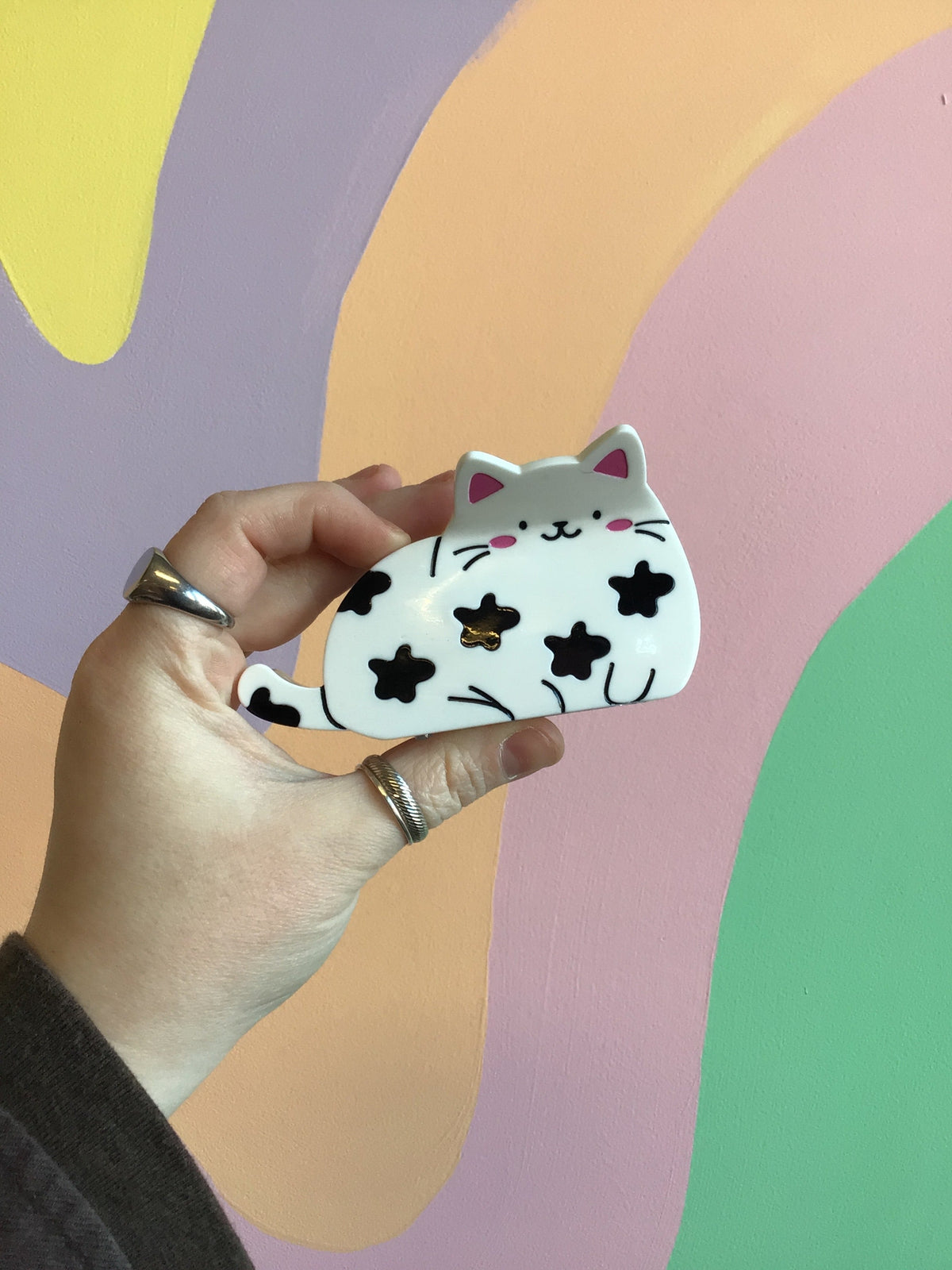 White cartoon cat hair claw clip with black patches, metal hinge and teeth