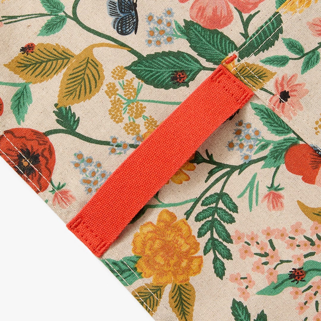 Floral apron corner with orange trim and stitched hem