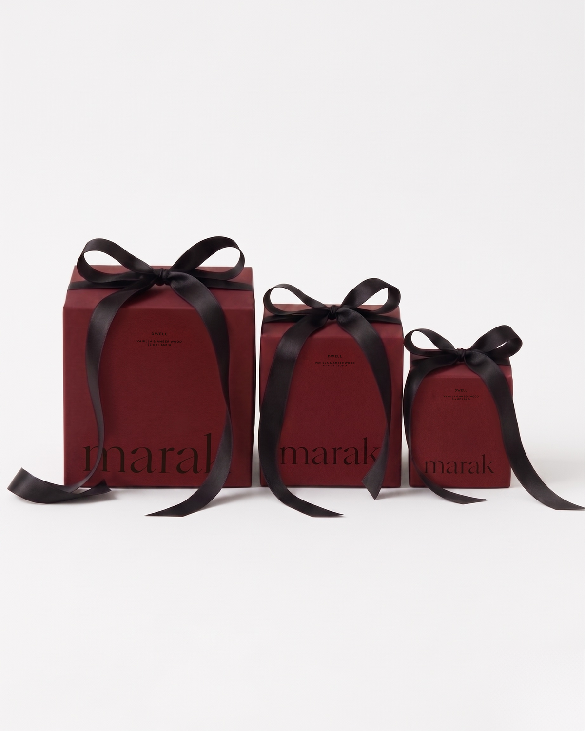 Three marak gift candles in maroon boxes with black ribbon bows, ready to gift