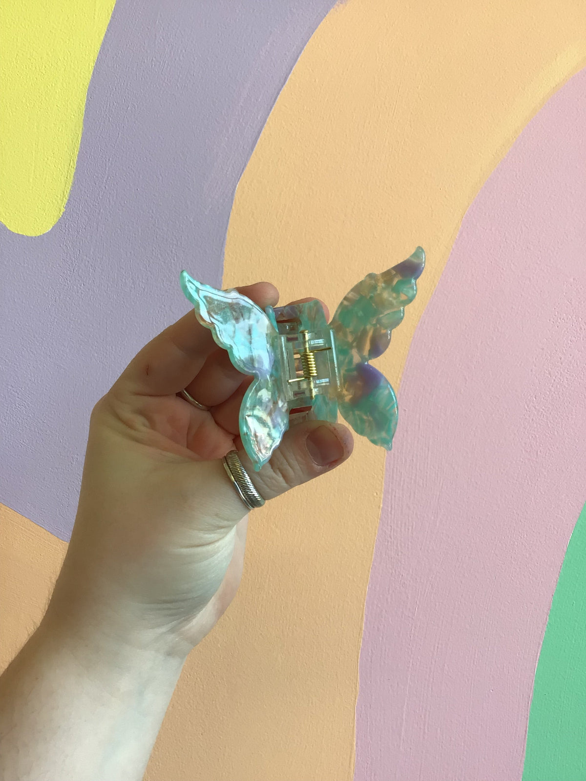 Butterfly hair claw with teal-green iridescent wings and metal hinged clip
