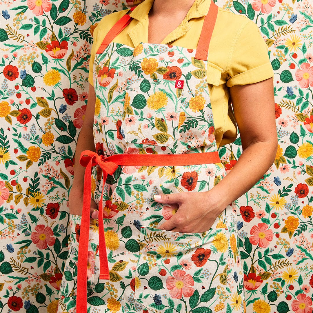 Floral apron featuring orange waist ties and neck strap