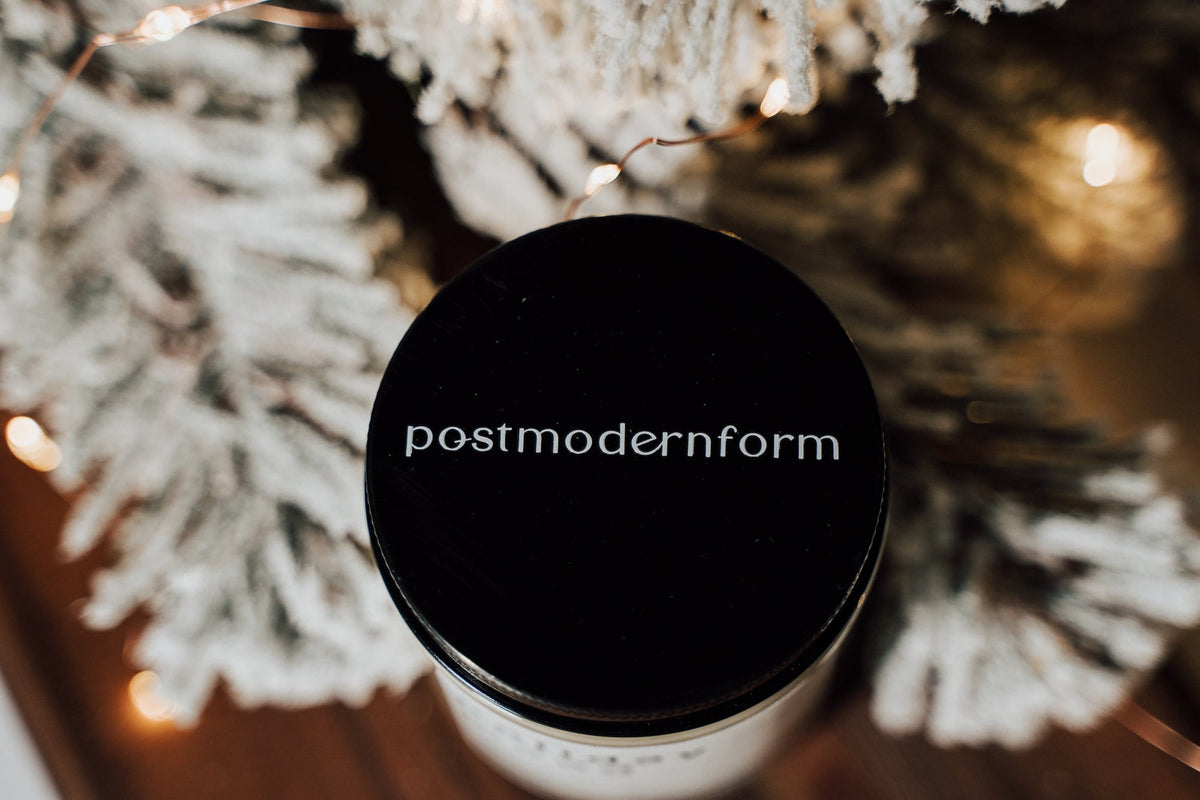 Round black candle lid with 'postmodernform' text