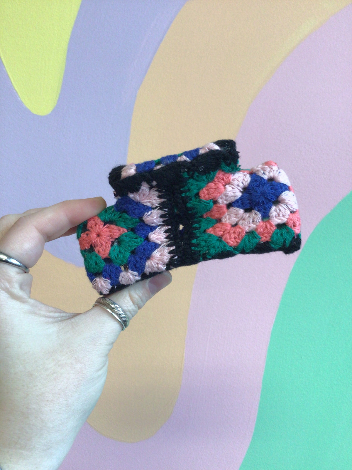 Crocheted hair claw with multicolor square crochet patchwork and dark trim