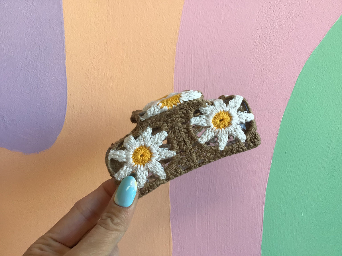 Crocheted hair claw in brown with white daisies and yellow centers