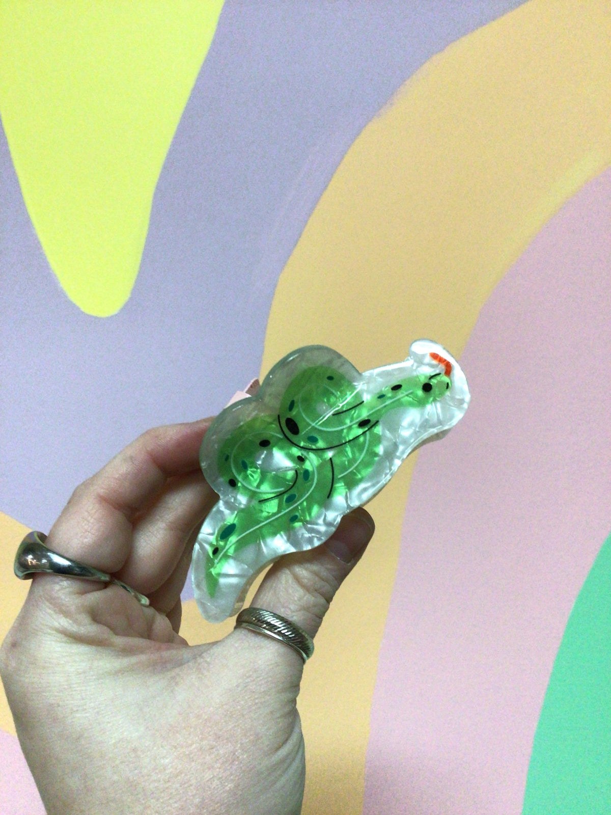 Green snake-shaped hair claw with curved teeth detail and glossy finish