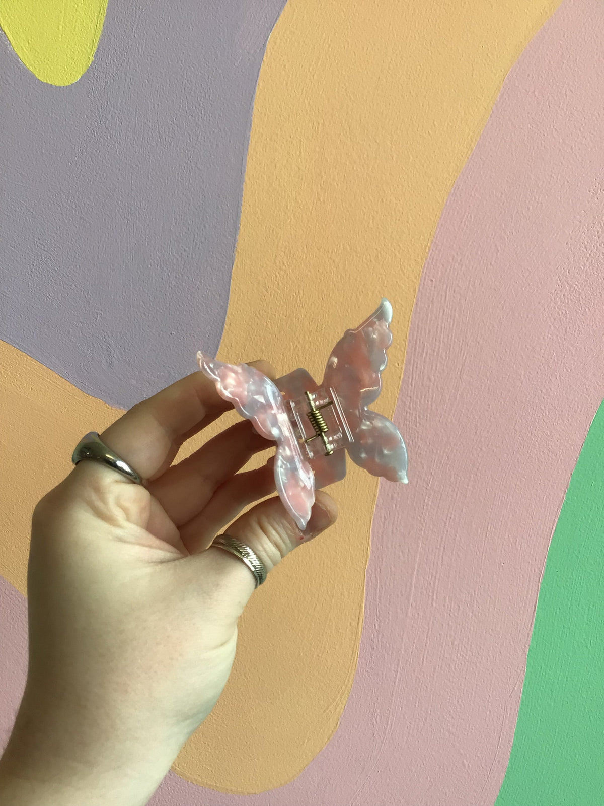 Butterfly hair claw with translucent pink wings and gold-tone center hinge