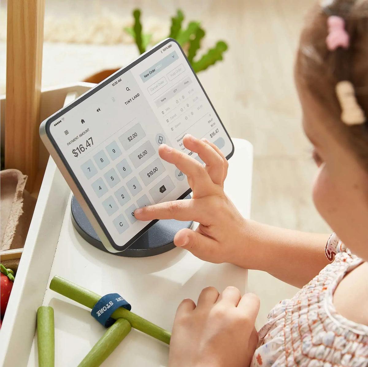 Grocery store playset with touchscreen cash register and toy vegetables.