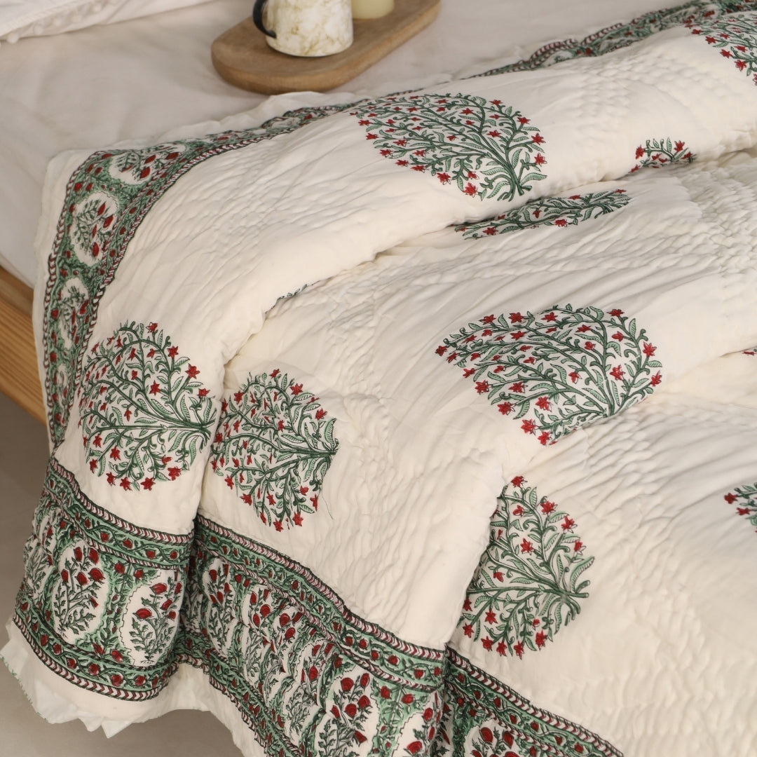 Green and red floral reversible quilt with medallion edge and stitched quilting texture