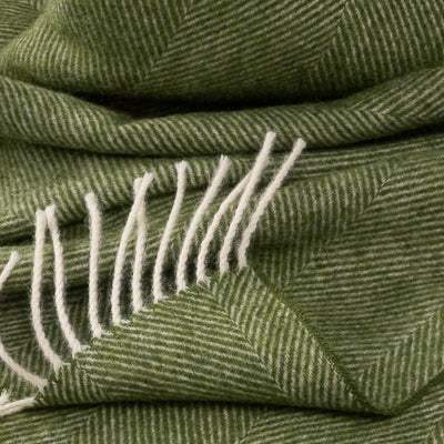 Close-up of evergreen herringbone weave with cream fringes