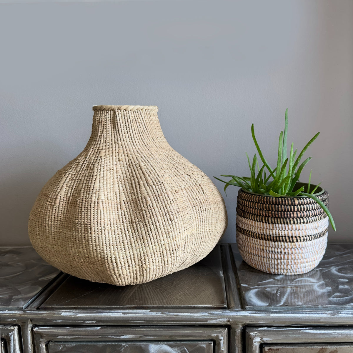 Pair of woven garlic baskets with rounded bulbs and narrow necks, natural beige