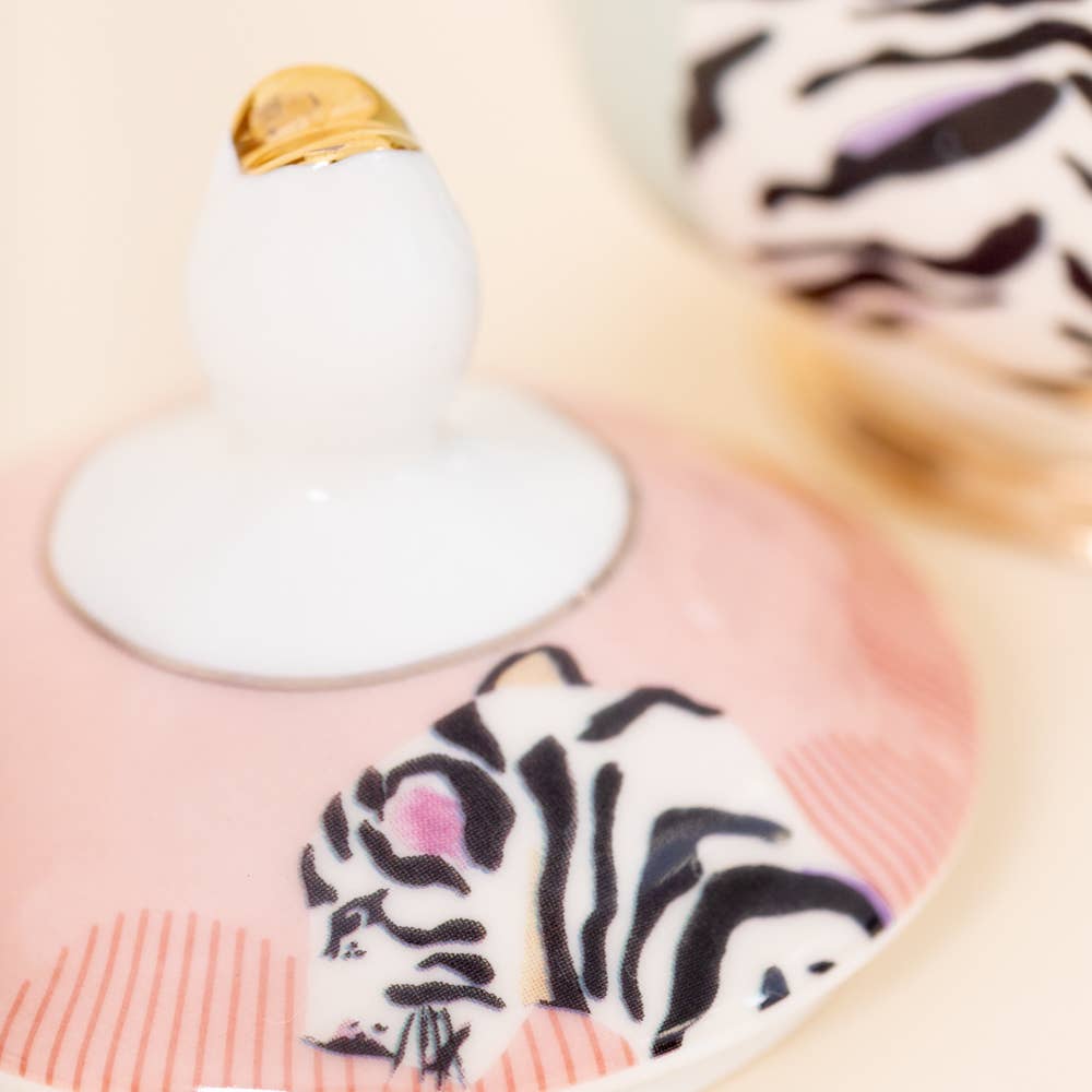 Sugar bowl lid close-up with white finial and zebra-style tiger artwork