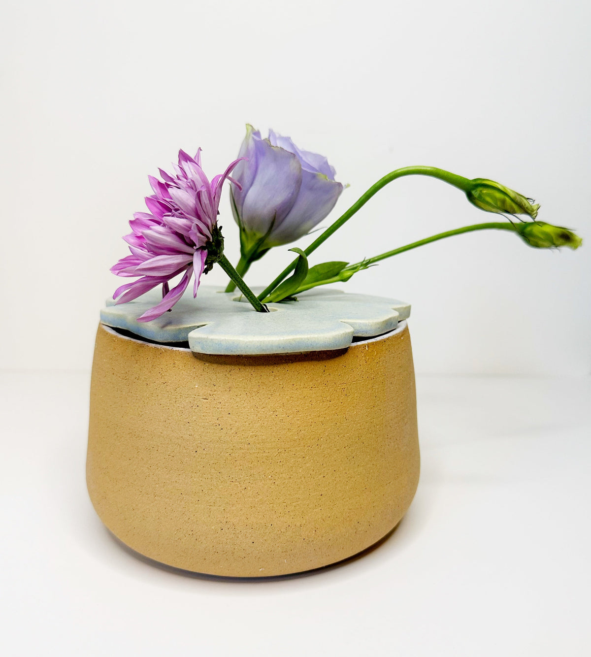 Large tan planter pot with a light blue frog-shaped decor piece on top