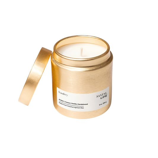 Amber sandalwood 9 oz candle in gold jar with foil lid and ribbon
