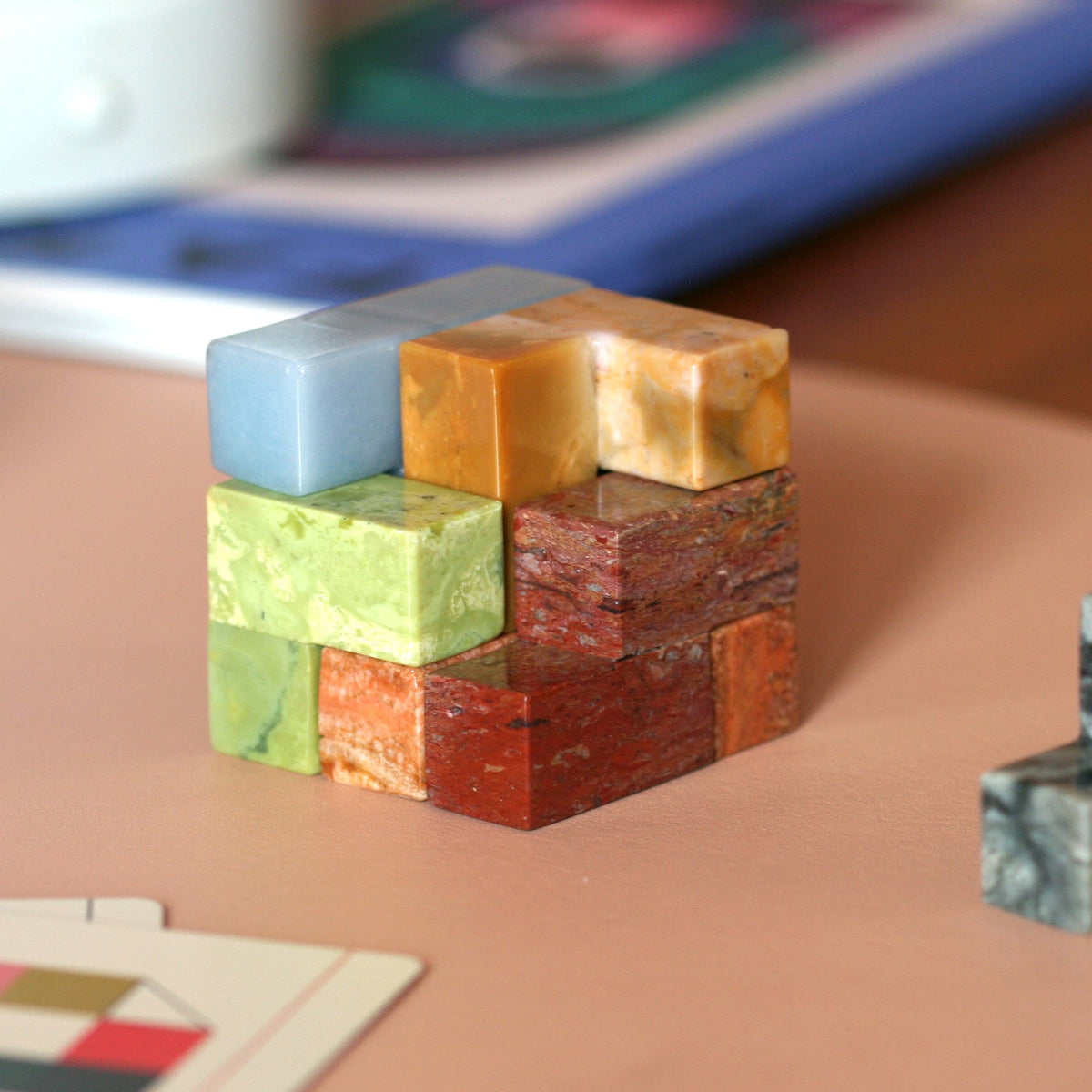 Gemstone Soma cube puzzle closeup of stacked multicolor stone blocks
