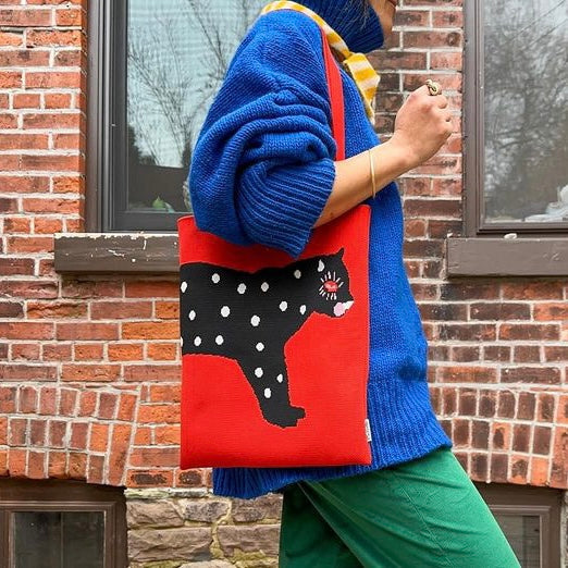 Red knit tote bag with black polka-dot cat design and sturdy shoulder straps.
