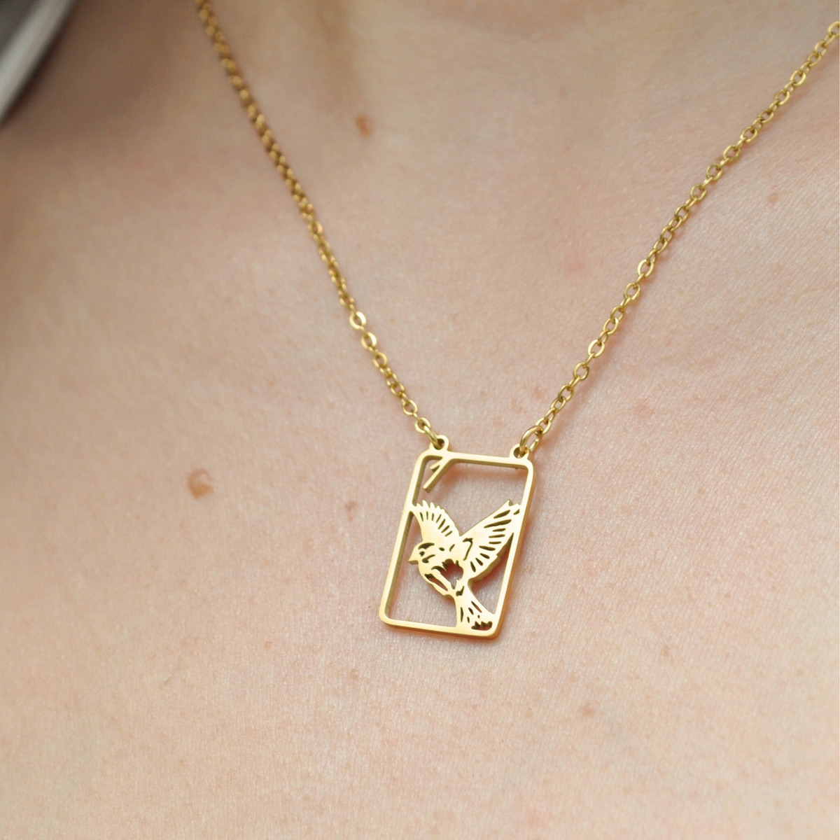 Gold necklace with square pendant and engraved bird filigree, thin chain
