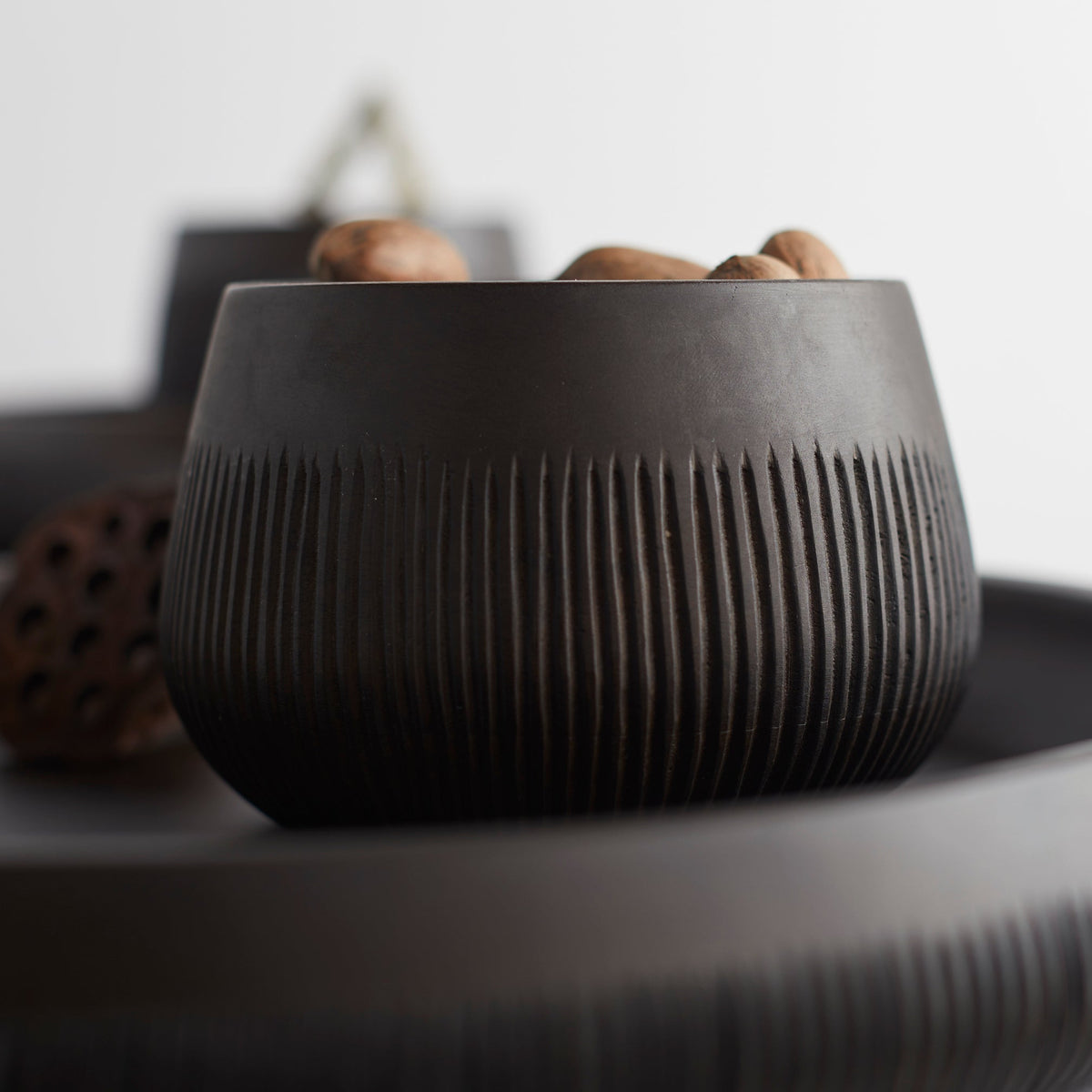 Black ridged ceramic bowl with fluted vertical texture and wide opening