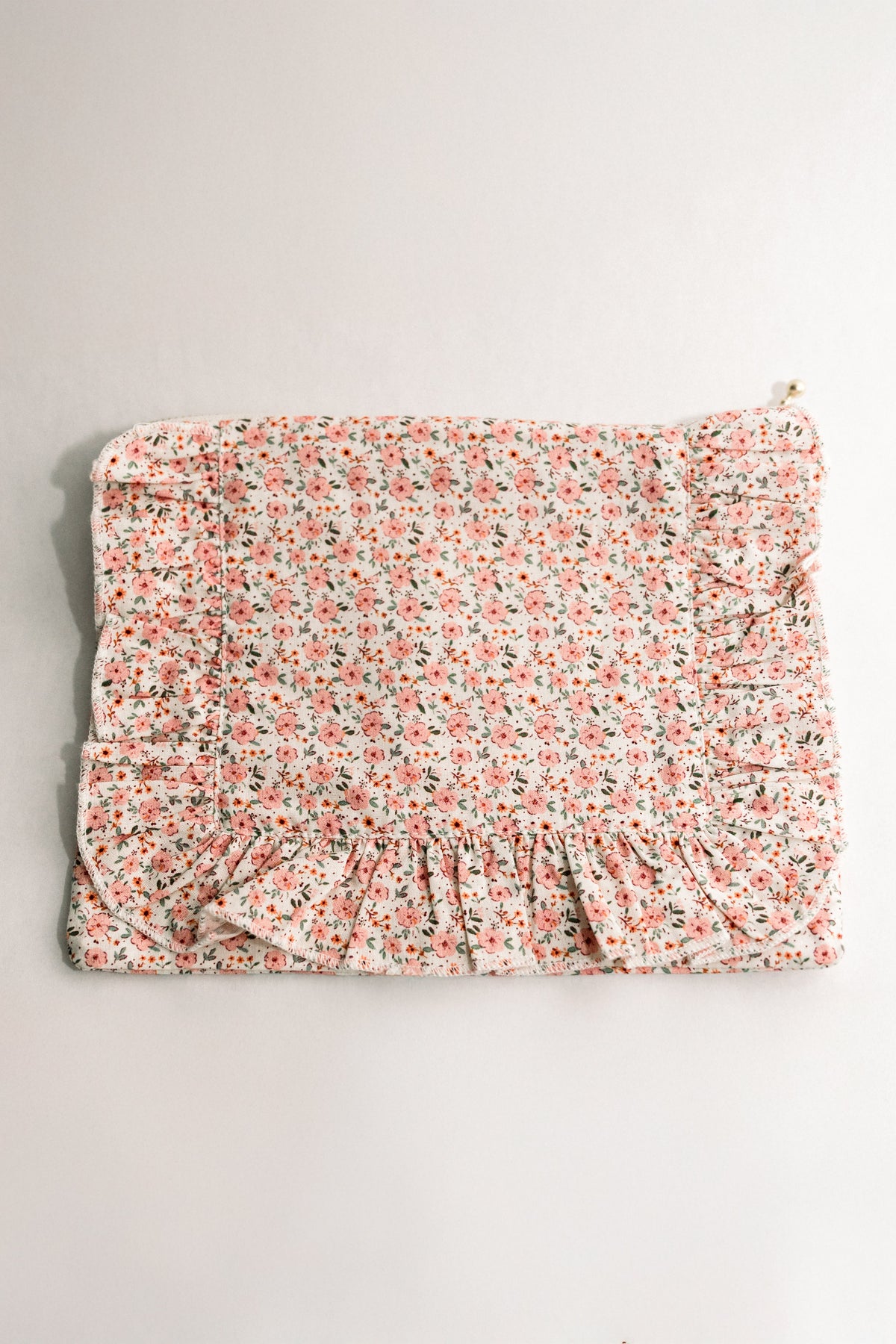 Peach floral ruffle zipper pouch with gathered front and gold zipper pull