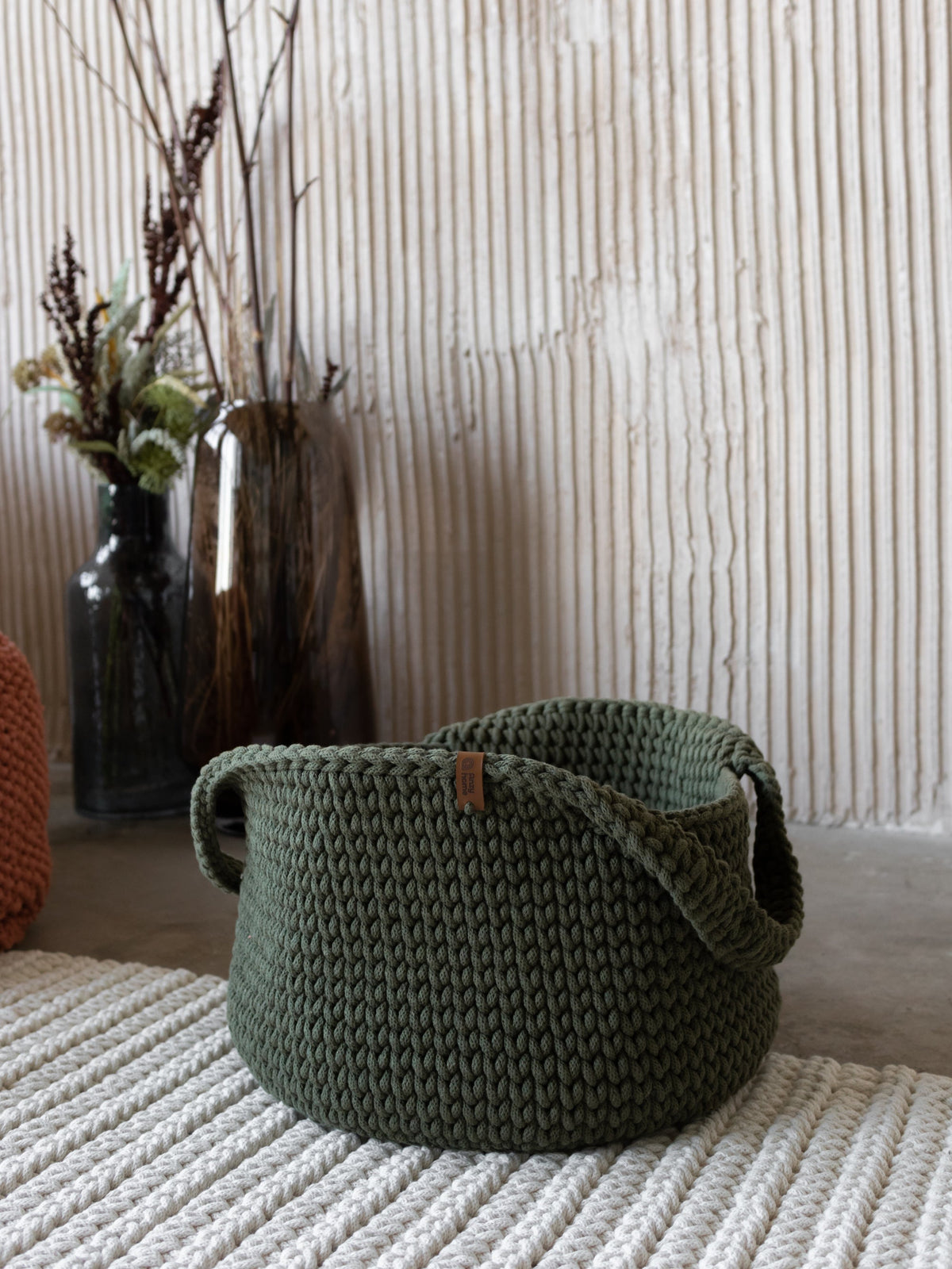 Round woven basket with handles, dark green fabric weave.