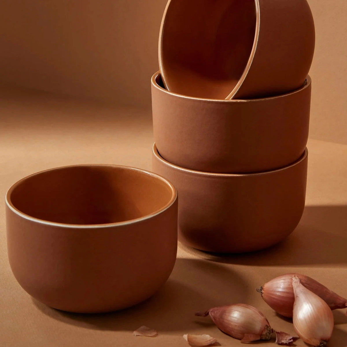 Terracotta ceramic bowls stacked, with serving bowl in front