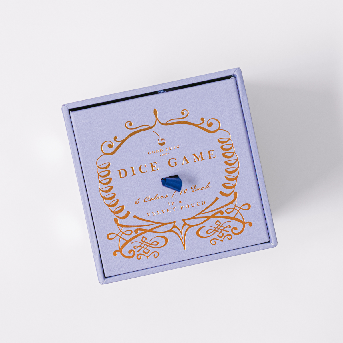 Blue gift box lid with orange ornamental dice-game design and lettering.