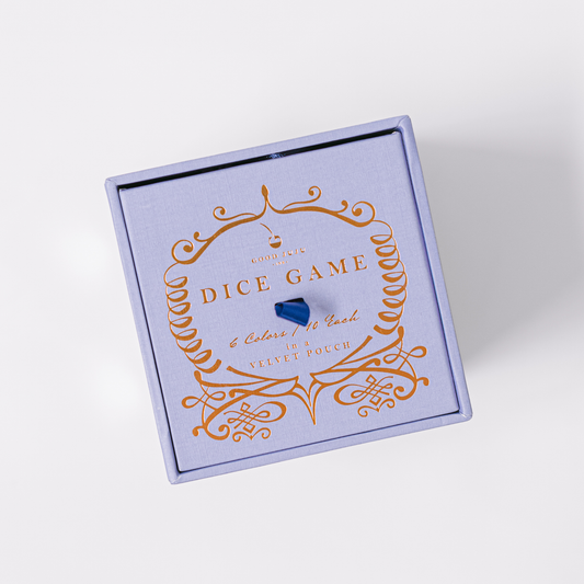Blue gift box lid with orange ornamental dice-game design and lettering.