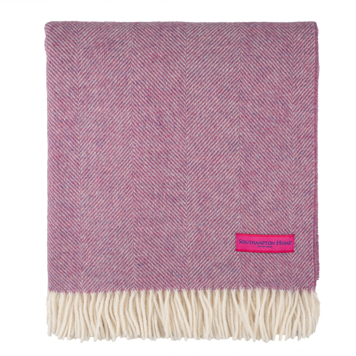 Petal pink herringbone throw blanket with cream fringe trim and stitched label
