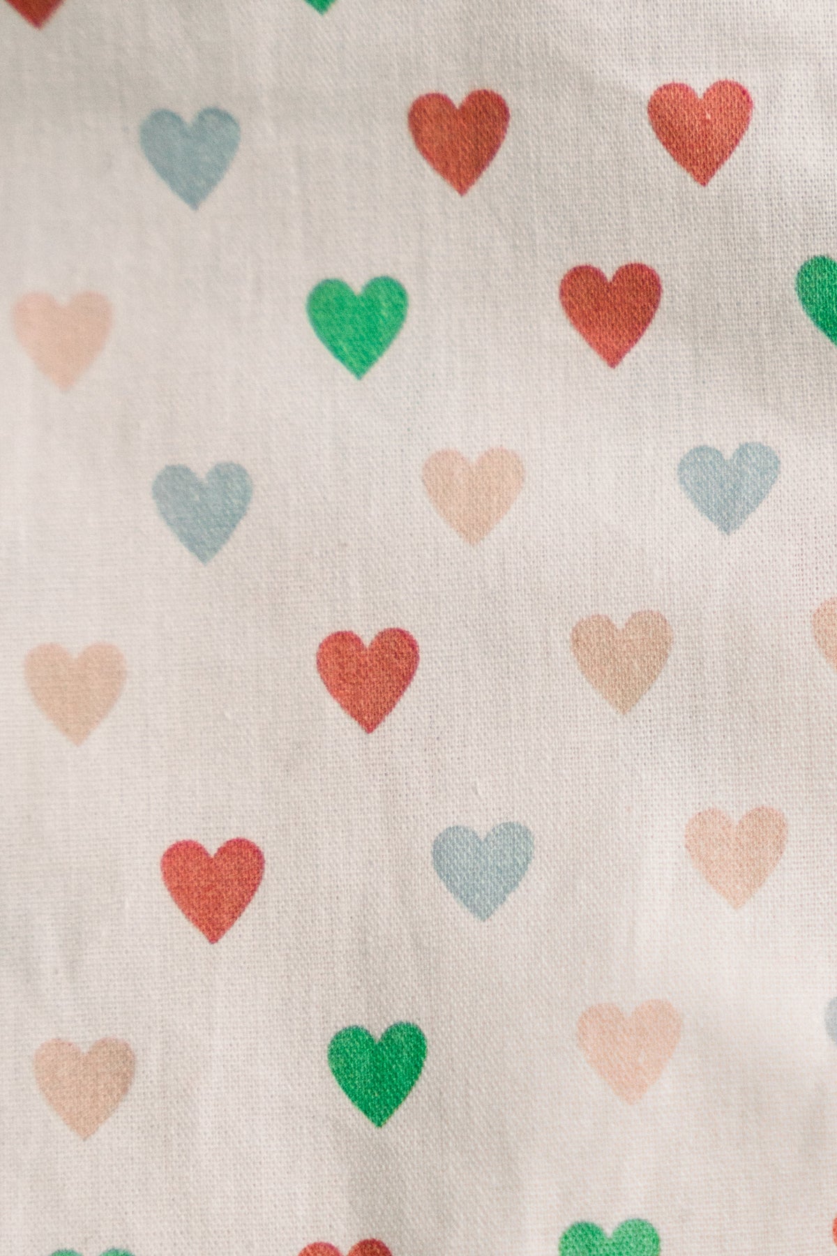 White fabric close-up with multi-color heart print