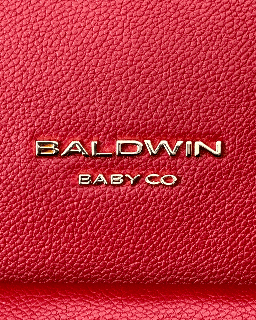 Close-up of the textured crimson bag exterior with gold Baldwin Baby Co. lettering.