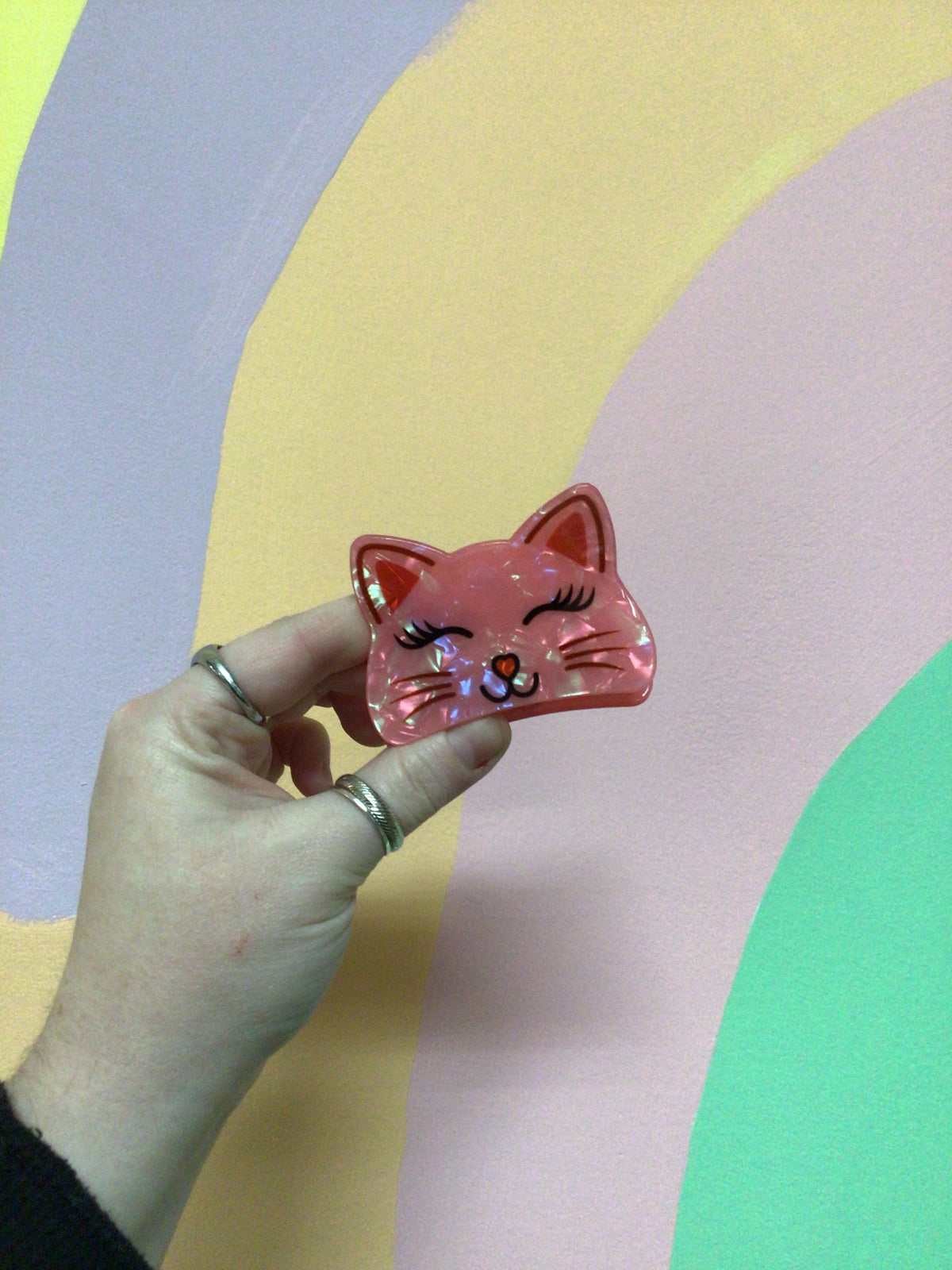 Pink kitty hair claw with closed-eye face and heart-and-nose details