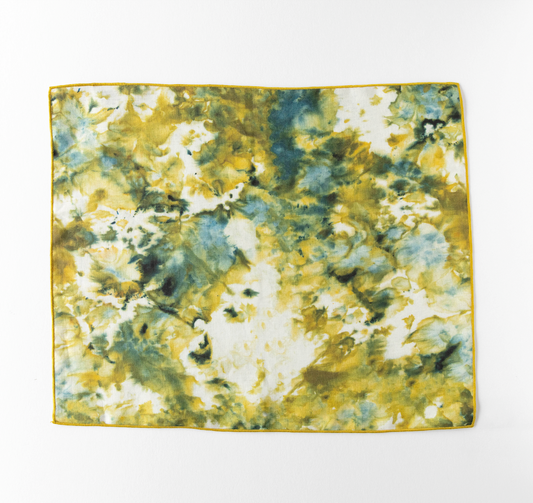 Marble-look placemat in green and yellow with thin gold edge trim, square shape