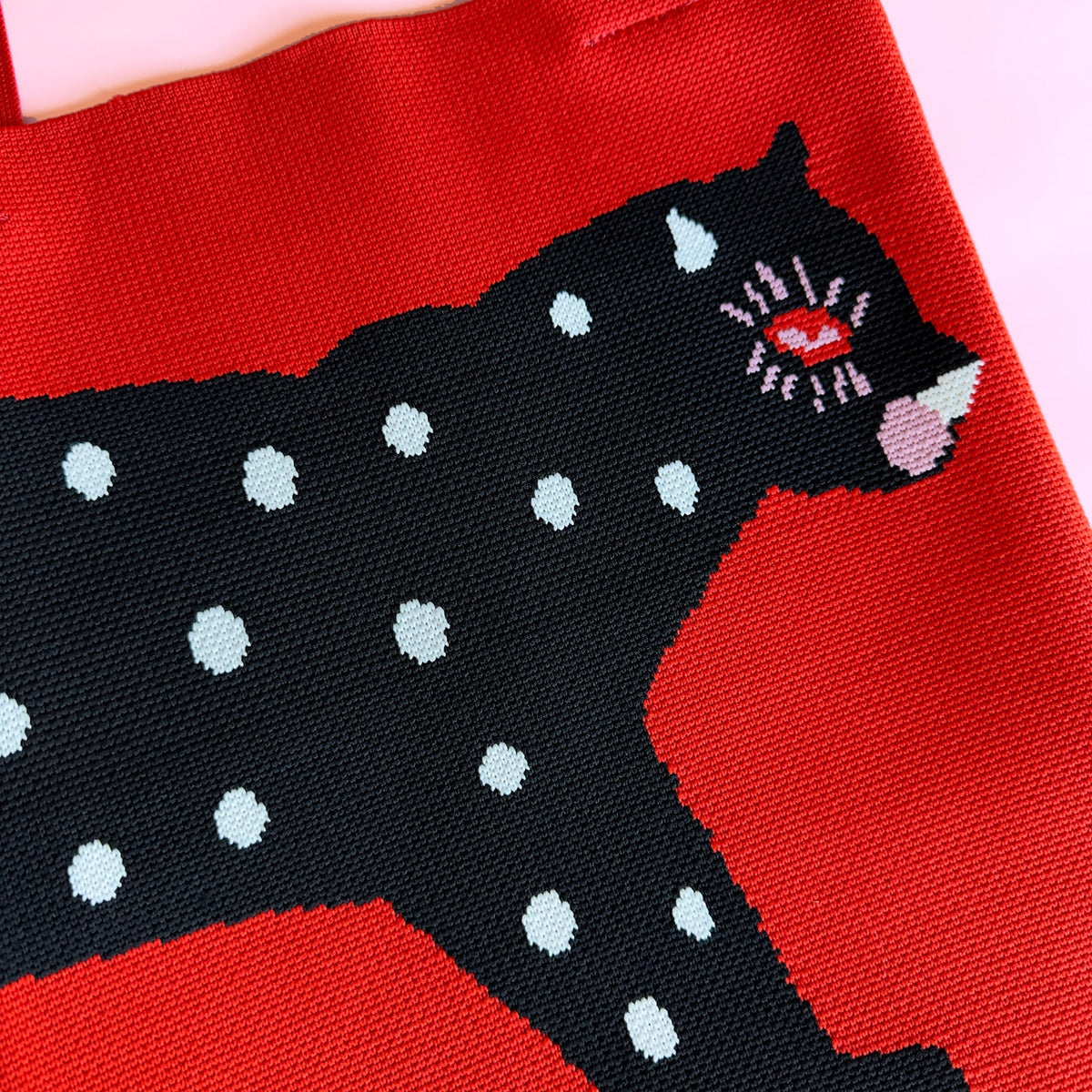 Knit tote fabric panel with black cat and white polka-dot details on red.