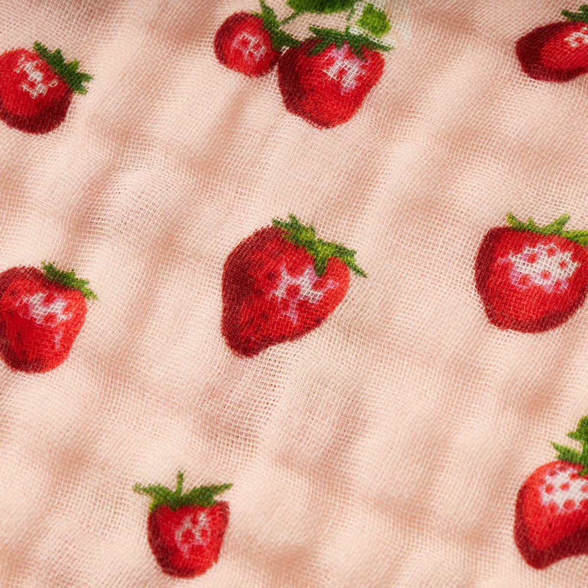 Peach net-like fabric swatch with scattered red strawberries and green leaves