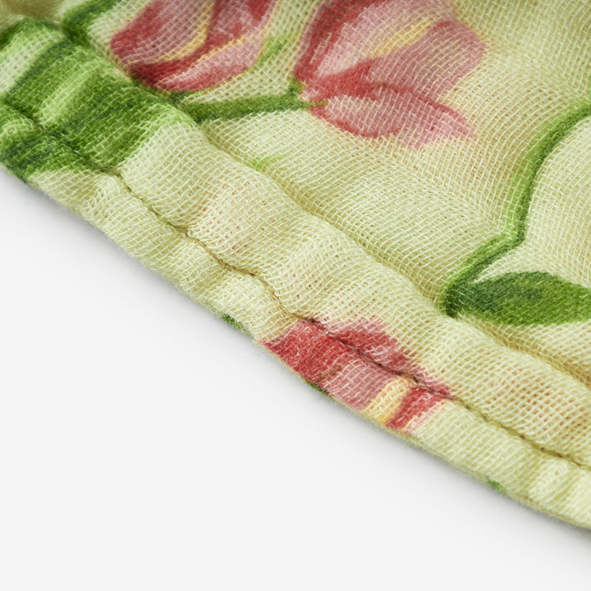 Textured woven beach towel corner with tulip pattern and stitched edge