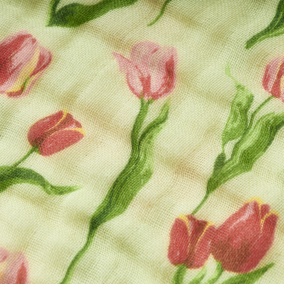Close-up of tulip print on woven fabric in light green and pink-red