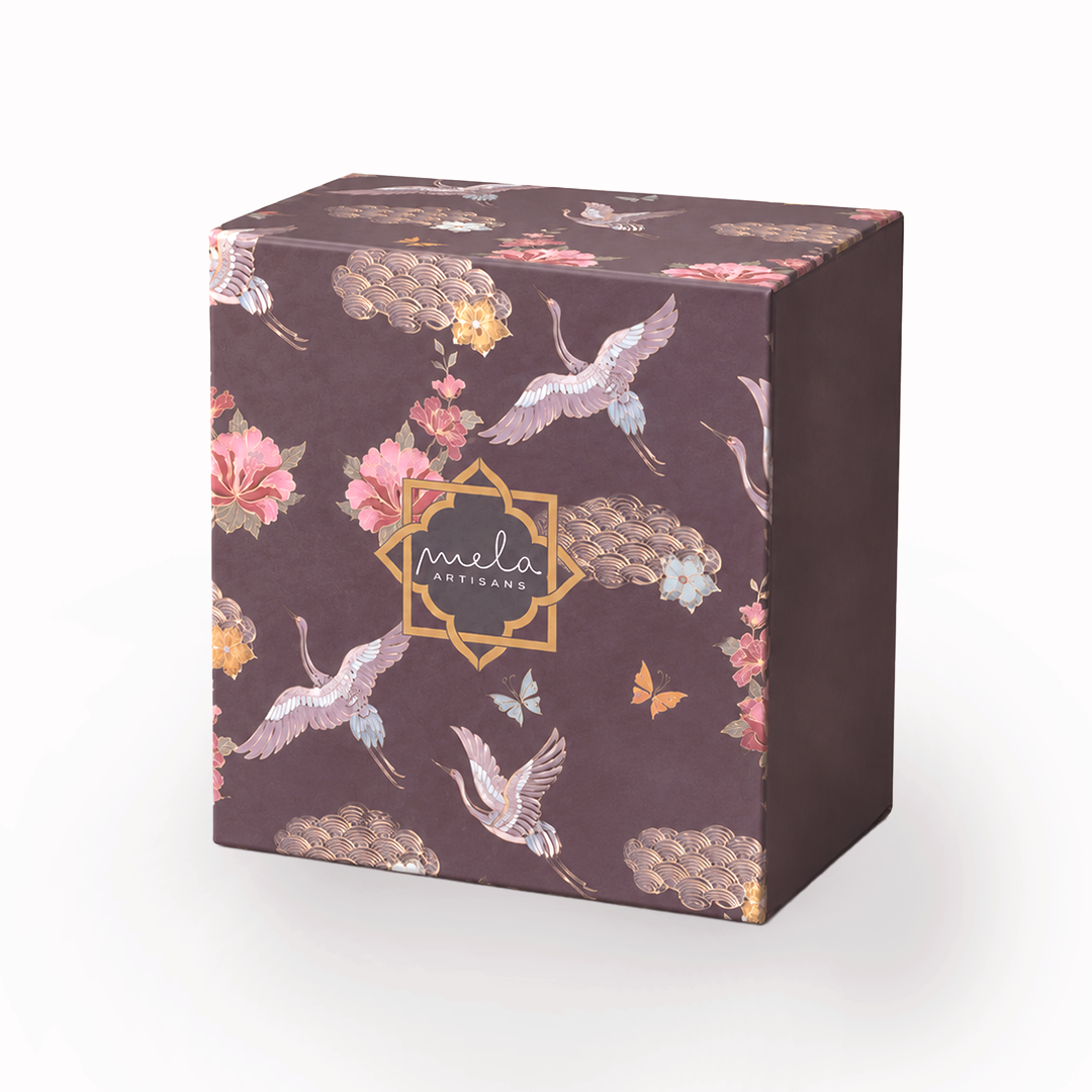 Medium decorative gift box in dark brown with floral, clouds, and “mela” logo