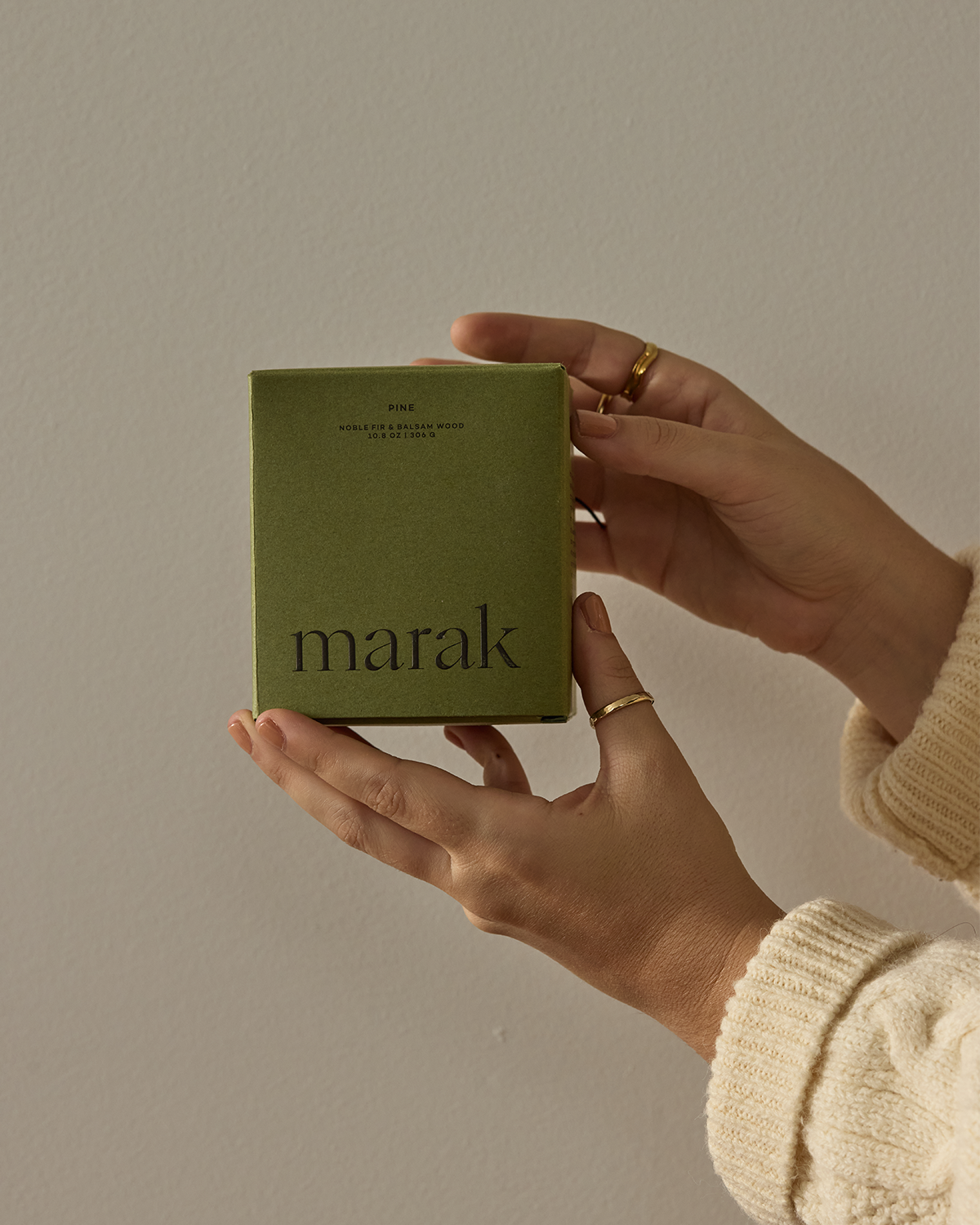 Hands holding a small green marak candle box