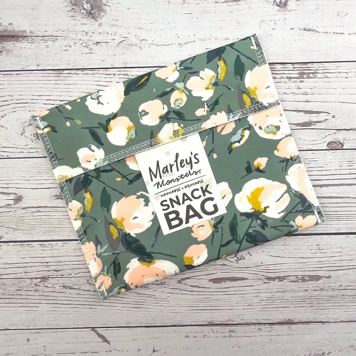 Reusable snack bag with dark green floral pattern, stitched edge detail on pouch